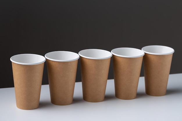 Disposable cardboard biodegradable cups on a white table gray background