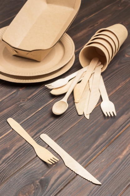 Disposable cardboard dishes, wooden forks and knives. Paper disposable tableware for fast food.