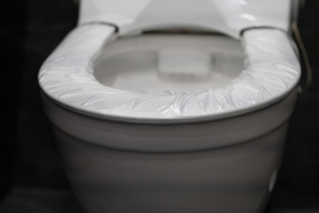 Disposable cover pad on the rim of the toilet seat wc hygiene system in public washroom toilet with automatic film change replacement system rim smart modern plumbing