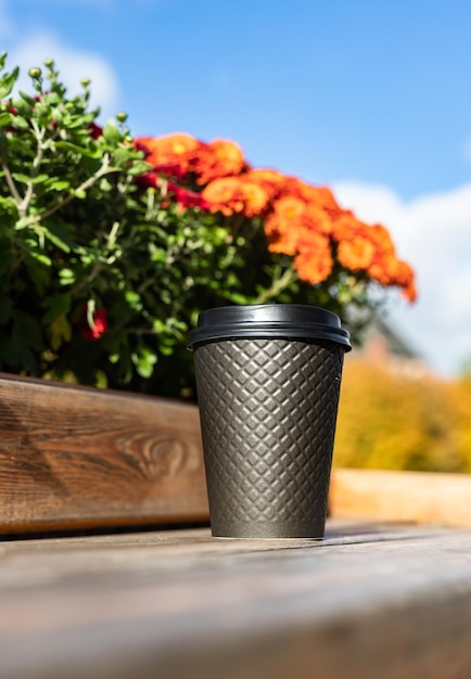 Disposable eco paper cup for drink with background of the city Takeaway drink Empty space for text