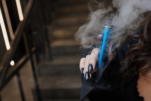 Disposable electronic cigarettes in hand. The concept of modern smoking, vaping and nicotine.