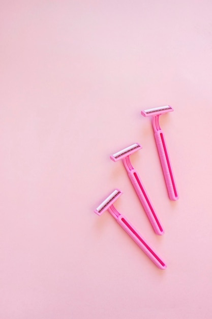 Disposable female razor on a pink background A tool to remove hair from the skin Female depilation and hygiene Body care Top view copy space stylish magazine concept