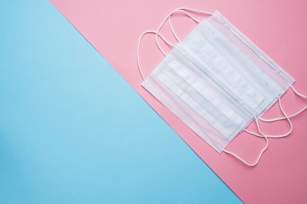 Disposable medical face masks on pink and blue