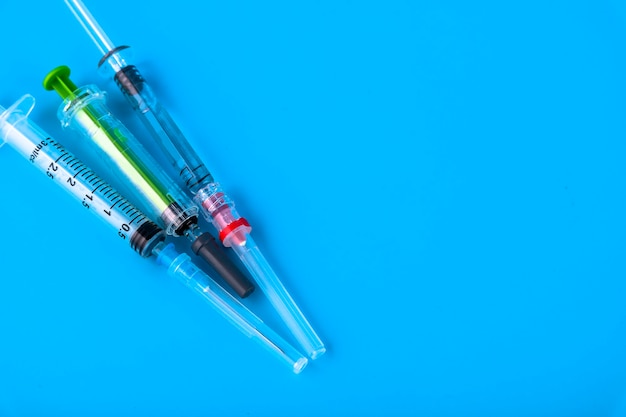 Disposable medical hypodermic syringes on a blue background. Copy space.