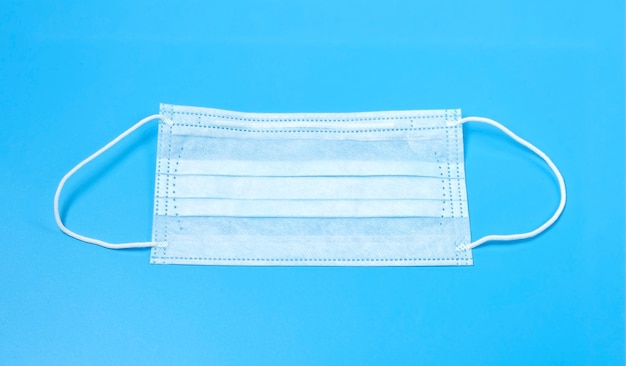 Disposable medical mask on a blue background.