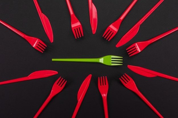 Disposable red and green plastic forks isolated on background