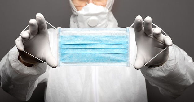 Disposable surgical protective mask in medical worker hands.