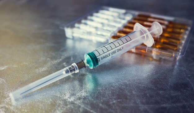 Disposable Syringe And Ampoules on a silver space, inscription single use only, shallow depth of sharpness