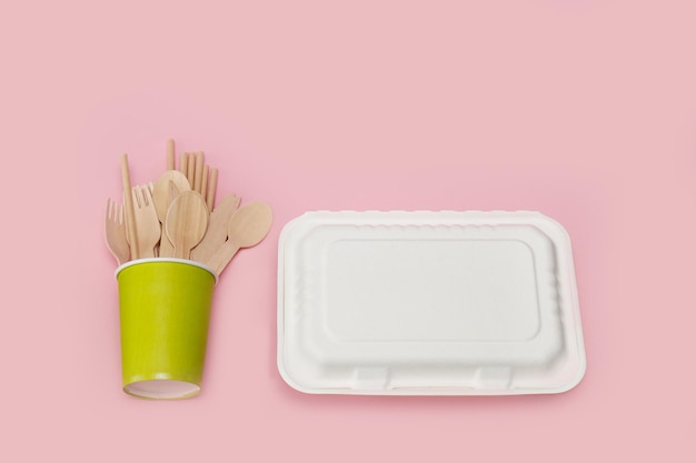 disposable wooden spoons forks and knives in a paper cup with a corn raw lunchbox container