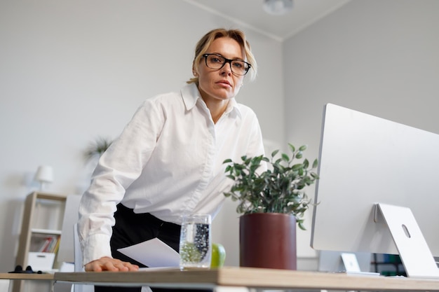 Dissatisfied serious middle aged business woman in the office looking angrily at the camera