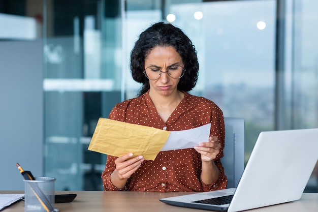 Dissatisfied and upset businesswoman received letter in envelope depressed latin american