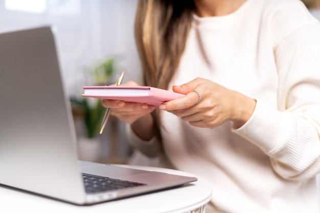 Distance learning online education and work. Business woman with headphones writes in notebook.