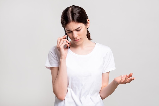 Disturbed woman portrait Phone call Annoyed lady having negative talk conversation isolated on neutral copy space Distance communication Information technology