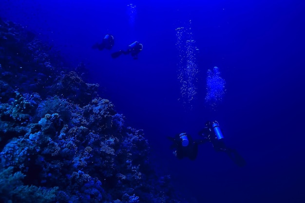 divers underwater at depth in the blue sea background