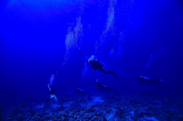 divers underwater at depth in the blue sea background