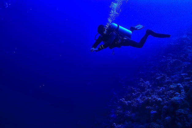 divers underwater at depth in the blue sea background