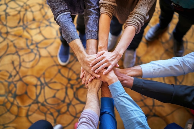 Photo diverse businesspeople standing with their hands together in an office high angle view of a group of