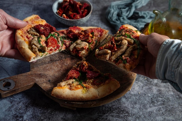 Diverse colleagues or friends take slices of vegan pizza and enjoy dinner