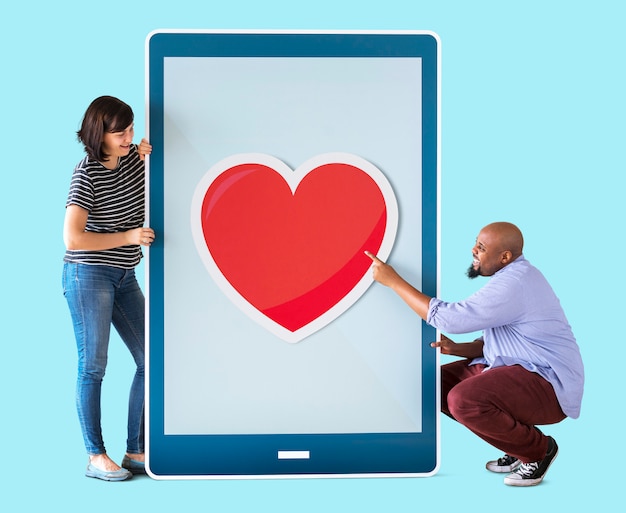 Diverse couple of people holding a tablet