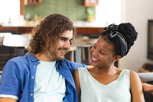 Diverse couple young African American woman and Caucasian man share a joyful moment on the couch