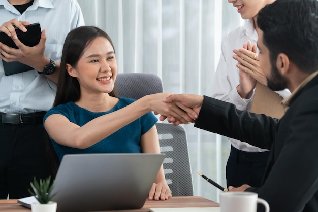 Diverse coworkers celebrate success with handshake Concord