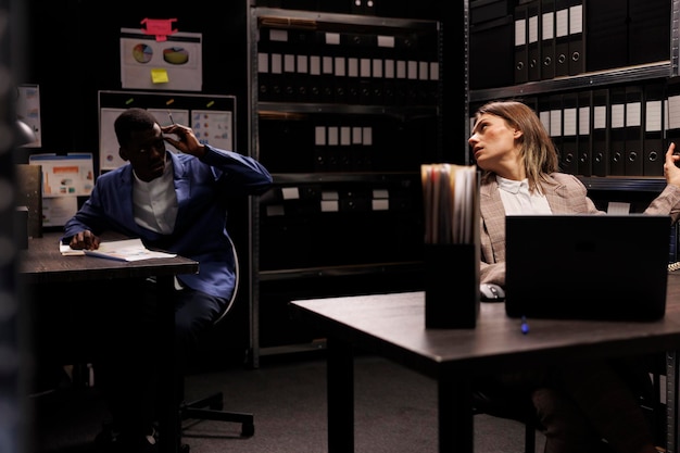 Diverse employees working at management research, searching for bureaucracy record in storage room. Businesspeople analyzing accountancy report, checking administrative documents