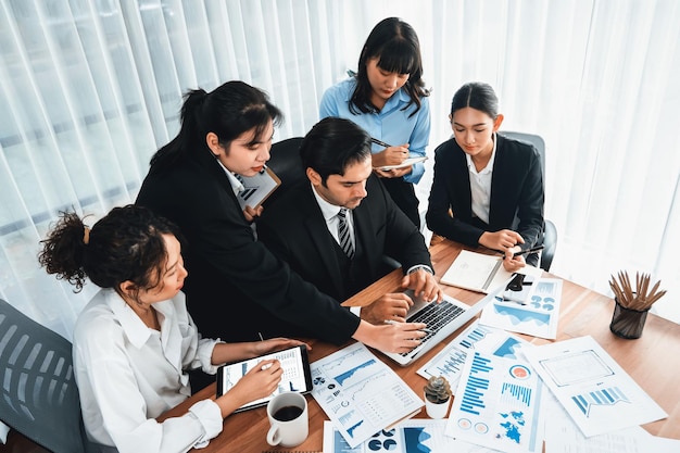 Diverse group of business analyst team analyzing financial data report paper on office table Chart and graph dashboard by business intelligence analysis for strategic marketing planning Meticulous