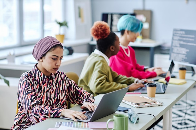 Diverse group of creative Muslim woman using laptop