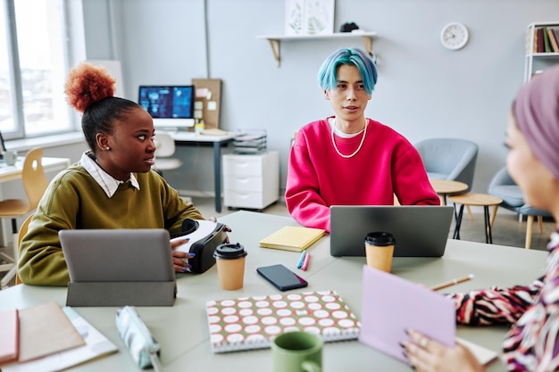 Diverse group of creative young people meeting in office focus on Asian man