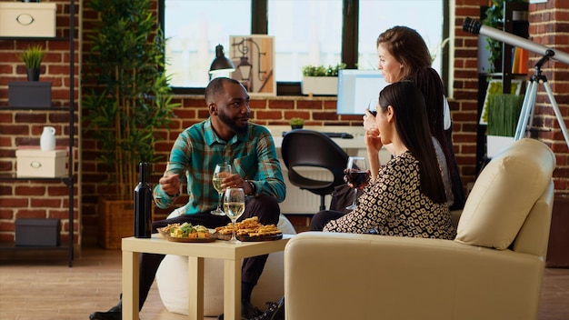 Diverse group of people throwing birthday party for their friend drinking wine and champagne