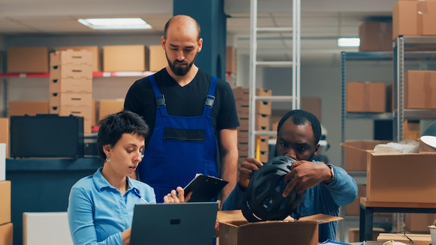 Diverse people shipping products from warehouse stock and packing merchandise in boxes. Entrepreneurs working on small business development and goods shipment, startup. Handheld shot.