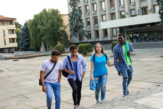 The diverse students leave the university after finish lessons