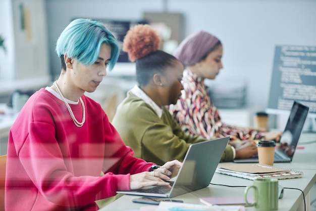 Diverse team of software developers using computers behind glass