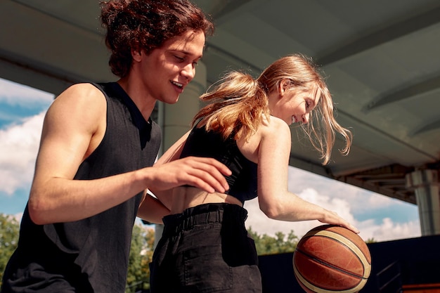 Diversity boys and girls play basketball sunny day