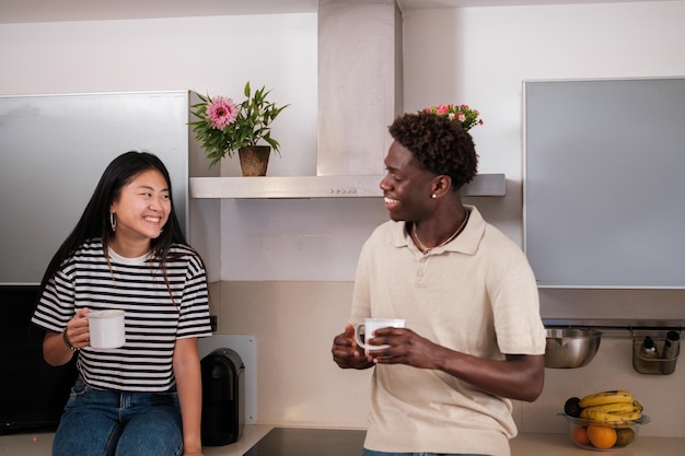 Diversity couple enjoying a coffee together with a good conversation in the kitchen at home Concept coffee break bond love