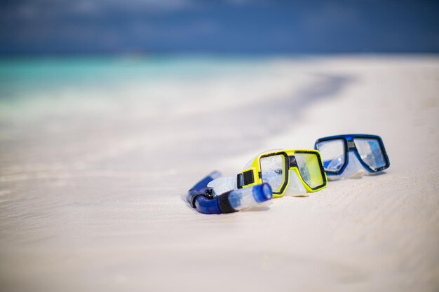 Diving goggles and snorkel gear on white sand near beach. Summer vacation and recreational travel