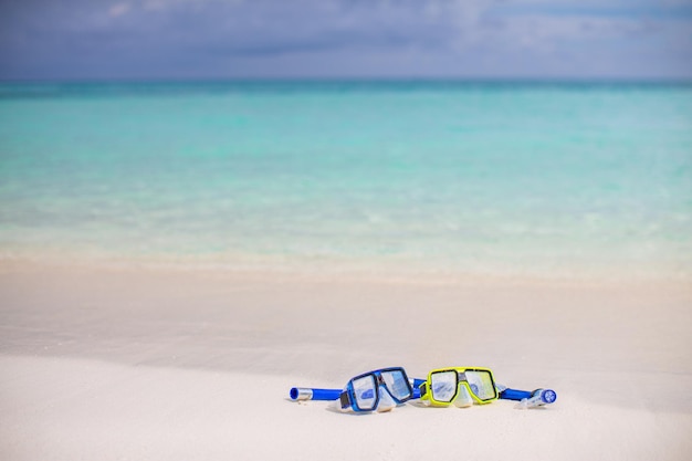 Diving goggles and snorkel gear on white sand near beach. Summer vacation and recreational travel