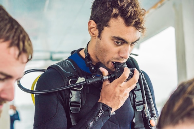 Diving instructor helps a beginner diver prepare for diving