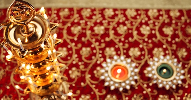 Diwali candles on a red carpet with floral ornaments