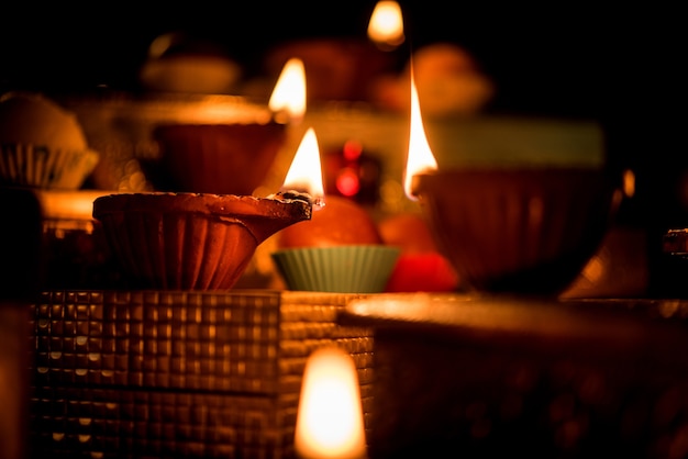 Diwali diya or lighting in the night with gifts, flowers over moody scene