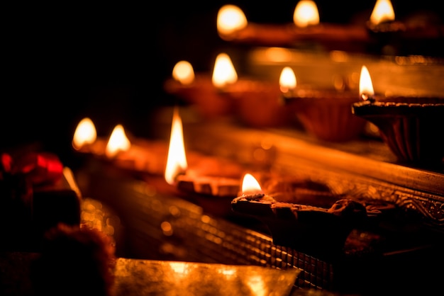 Diwali diya or lighting in the night with gifts, flowers over moody scene