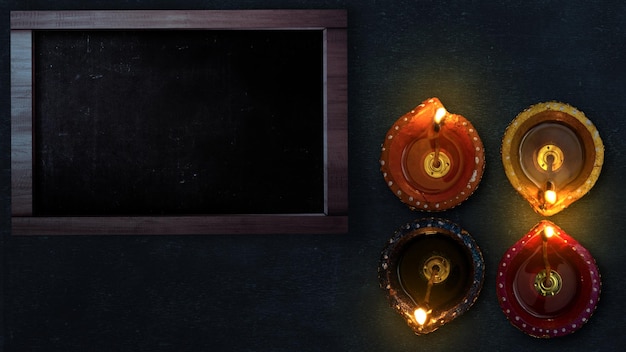 Diya oil lamps for the Diwali festival with an empty chalkboard for copy space Diwali Festival The Hindu Festival of Lights celebration