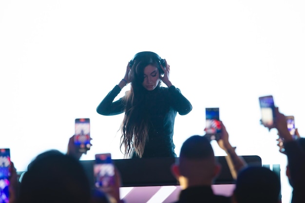 Dj girl working at the remote control in the club