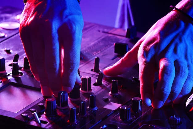 DJ mixing tracks on a mixer in a nightclub