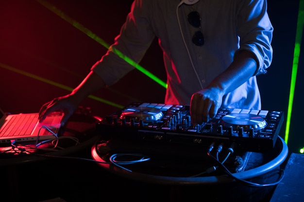 DJ playing turntable music on night club party