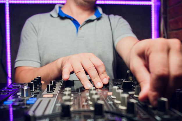 DJ remote, turntables, and hands . Night life at the club, party.