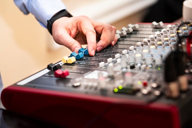 DJ switches slides and works with music tracks on the dashboard of the audio mixer