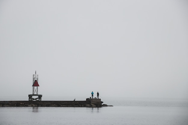 A dock leading to the ocean foggy