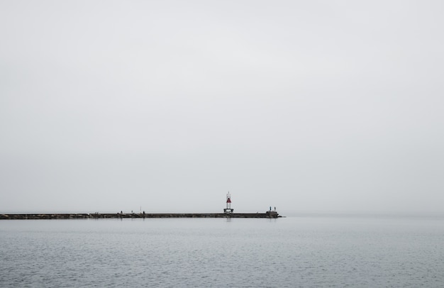 A dock leading to the ocean foggy