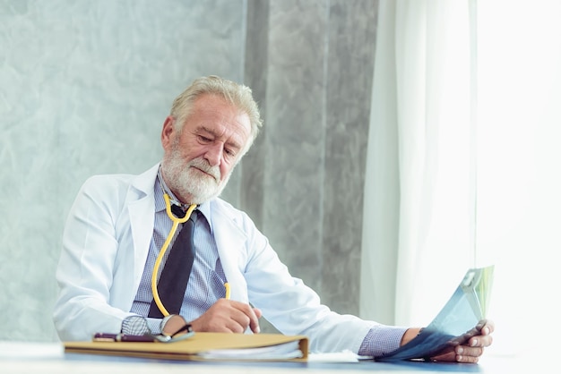 Doctor analyzing x-ray image at desk in hospital